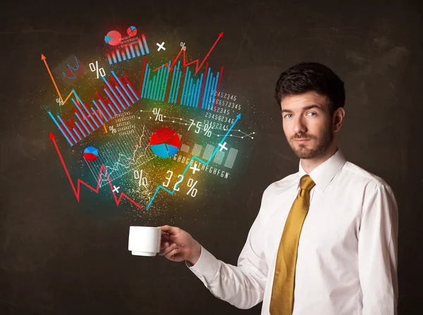 Empresario sosteniendo una taza blanca con diagramas y gráficos — Foto de Stock