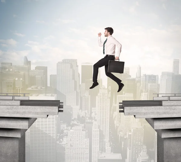Energetische zakenman springt over een brug met kloof — Stockfoto