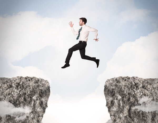 Funny business man jumping over rocks with gap