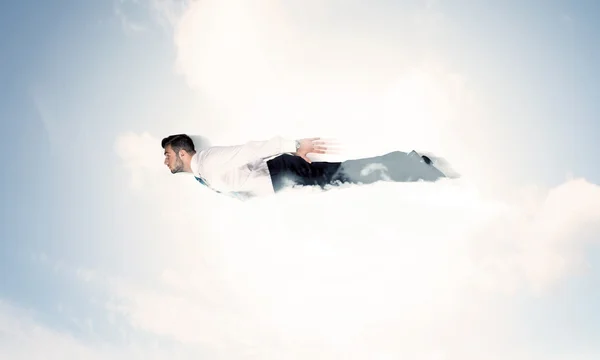 Affärsman flyger som en superhjälte i molnen på himlen — Stockfoto