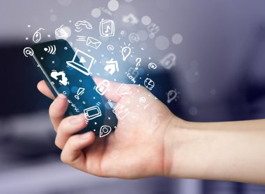 Medya simgeleri ve sembolleriyle el ele tutuşan akıllı telefon 