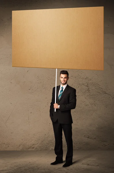 Businessman with blank cardboard — Stock Photo, Image