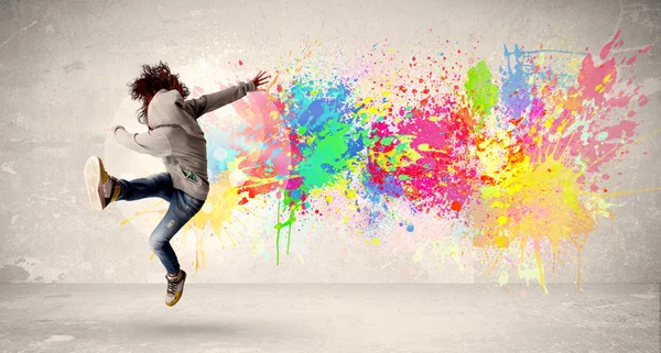 Mutlu genç renkli mürekkep sıçramak ile kentsel backg atlama — Stok fotoğraf