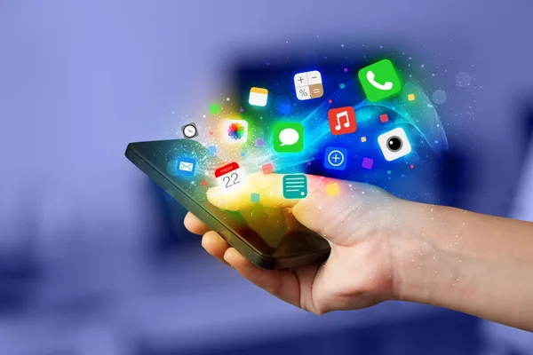 Mão segurando smartphone com ícones de aplicativos coloridos — Fotografia de Stock