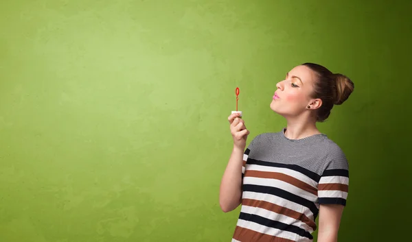 Hermosa mujer soplando burbuja de jabón sobre fondo de copyspace — Foto de Stock