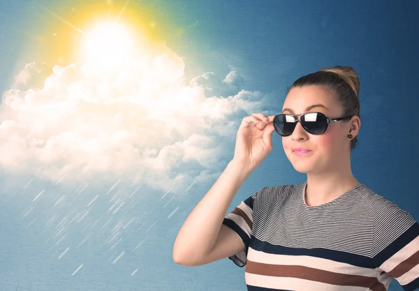 Young person looking with sunglasses at clouds and sun — Stock Photo, Image