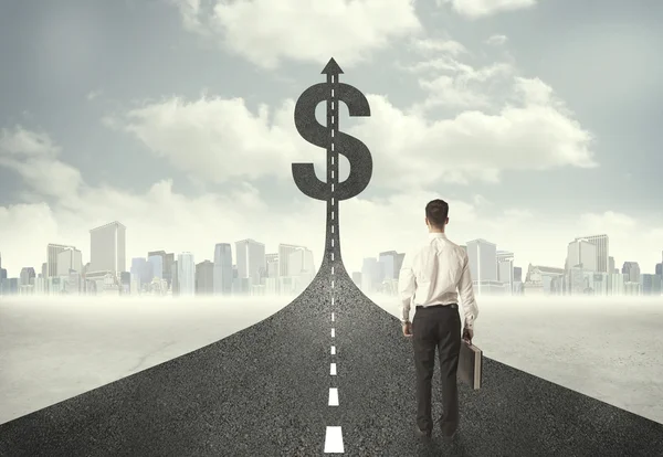 Business man on road heading toward a dollar sign — Stock Photo, Image