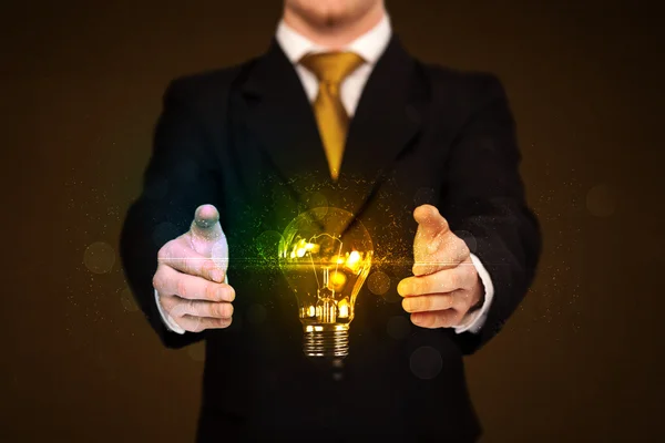 Businessman holding light bulb — Stock Photo, Image