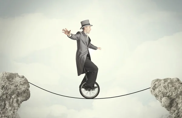 Brave business man riding an mono cycle between cliffs — Stock Photo, Image