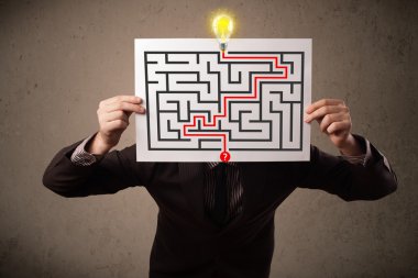 bir labirent ile bir kağıt üzerinde h tutan işadamı
