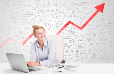 Piyasa diyagramlarıyla masada oturan iş kadını. 