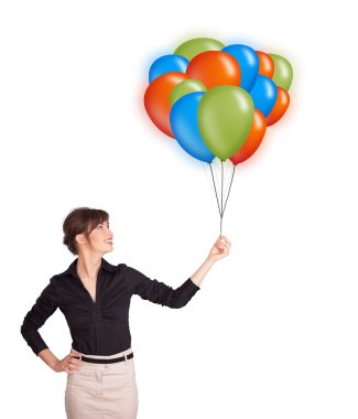 Genç bir kadın elinde renkli balonlar tutuyor.