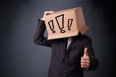 Businessman gesturing with a cardboard box on his head with excl clipart