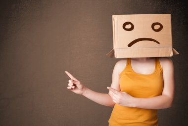 genç kız s başı üzerinde kahverengi karton kutu ile el hareketi