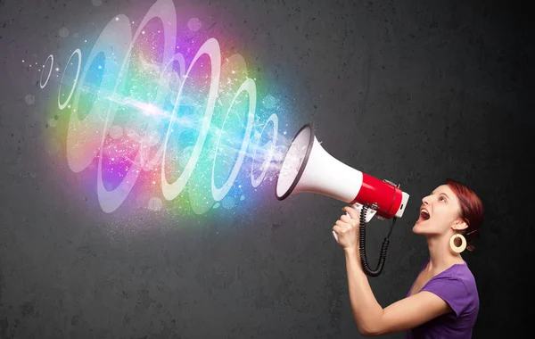 Chica joven grita en un altavoz y colorido rayo de energía com — Foto de Stock