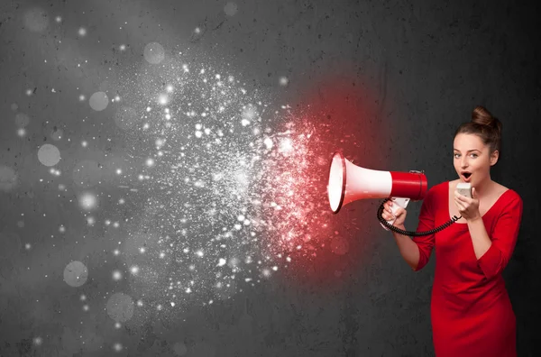 Woman shouting into megaphone and glowing energy particles explo — Stock Photo, Image