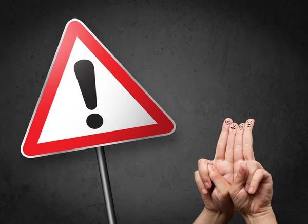 Happy smiley fingers looking at triangle warning sign with excla — Stock Photo, Image