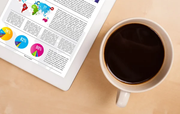 Tablet PC muestra noticias en pantalla con una taza de café en un escritorio — Foto de Stock