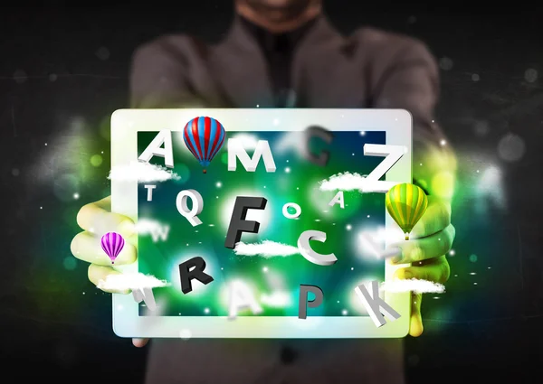 Young person showing tablet with abstract letters and sky — Stock Photo, Image