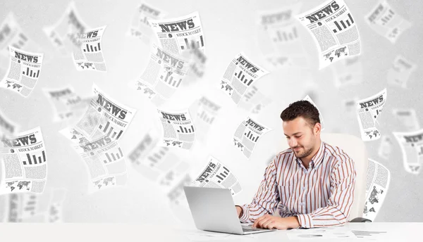 Business man at desk with stock market newspapers — Stock Photo, Image