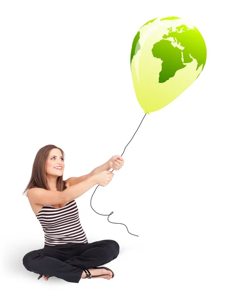 Senhora feliz segurando um balão globo verde — Fotografia de Stock