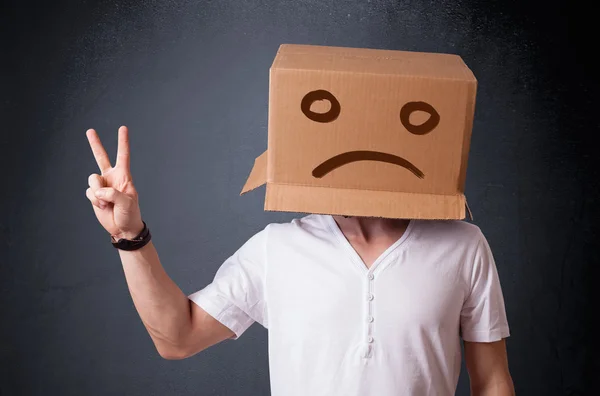 Jongeman met een bruine kartonnen doos op zijn hoofd met droevig gezicht — Stockfoto