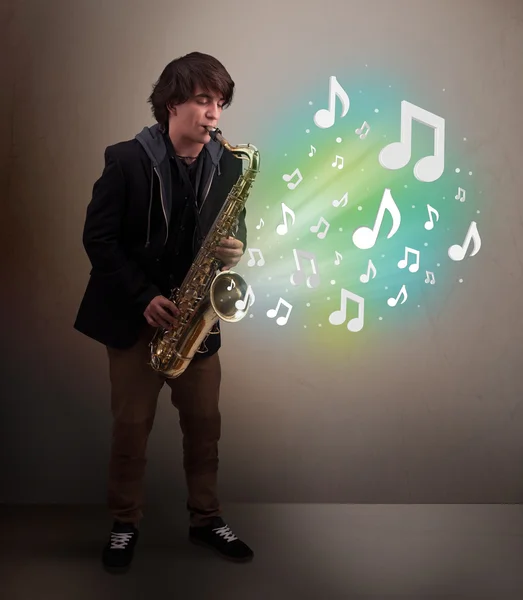 Jeune musicien jouant sur saxophone tandis que les notes de musique explosent — Photo