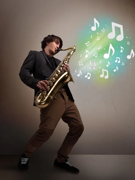 Young musician playing on saxophone while musical notes explodin — Stock Photo, Image