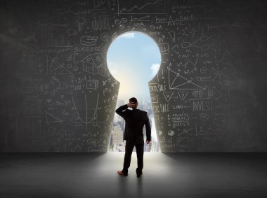 Parlak şehir manzaralı anahtar deliğine bakan bir işadamı 