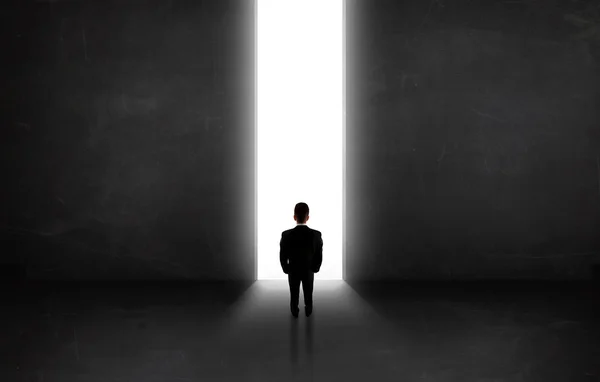 Бизнесмен смотрит на стену с открытием светового тоннеля — стоковое фото