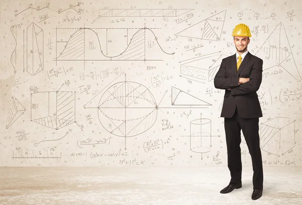 Handsome engineer calculating with hand drawn background — Stock Photo, Image