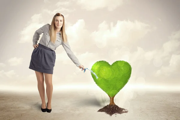 Zakenvrouw drenken hart gevormde groene boom — Stockfoto