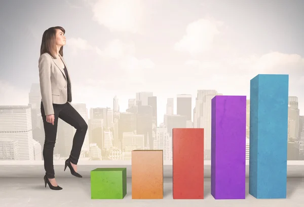 Bedrijfspersoon klimmen op kleurrijke grafiek pijlers concept — Stockfoto