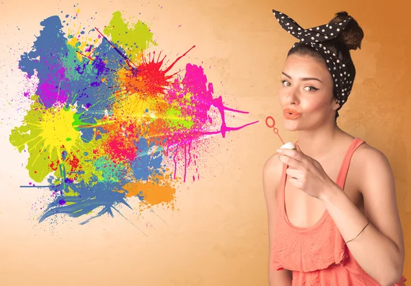 Roztomilé dívka foukání barevné stříkající graffiti — Stock fotografie