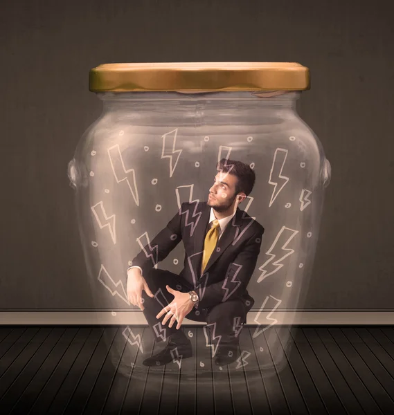 Homme d'affaires à l'intérieur d'un bocal en verre avec des dessins de foudre concept — Photo