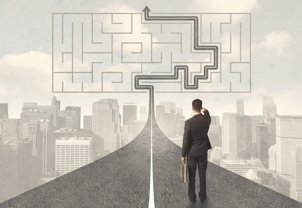 Бизнесмен смотрит на дорогу с лабиринтом и решением