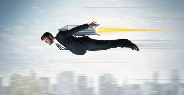 Superhero business man flying with jet pack rocket above the cit — Stock Photo, Image