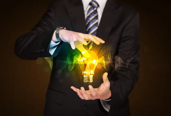 Businessman holding light bulb — Stock Photo, Image