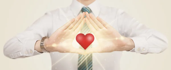 Τα χέρια δημιουργούν μια μορφή με λαμπερή καρδιά — Φωτογραφία Αρχείου