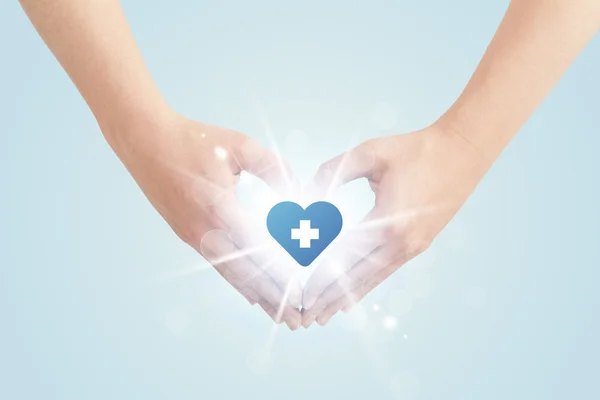 Mani che creano una forma con croce blu cuore — Foto Stock