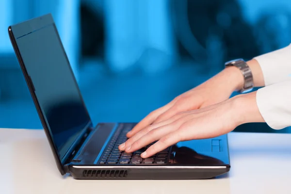 Empresário pressionando computador portátil moderno em backgrou colorido — Fotografia de Stock