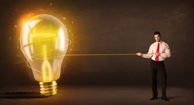 parlak parlayan büyük ampulü çekerek iş adamı