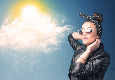 Güneş gözlükleriyle bulutlara ve güneşe bakan genç adam