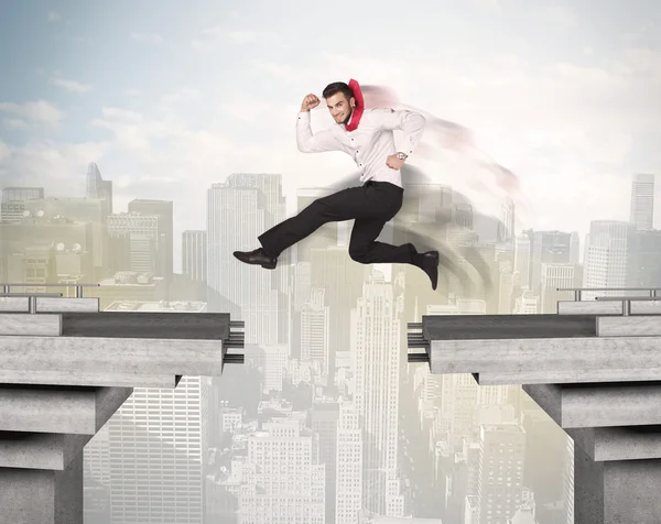 Энергичный бизнесмен, прыгающий через мост с разломом — стоковое фото