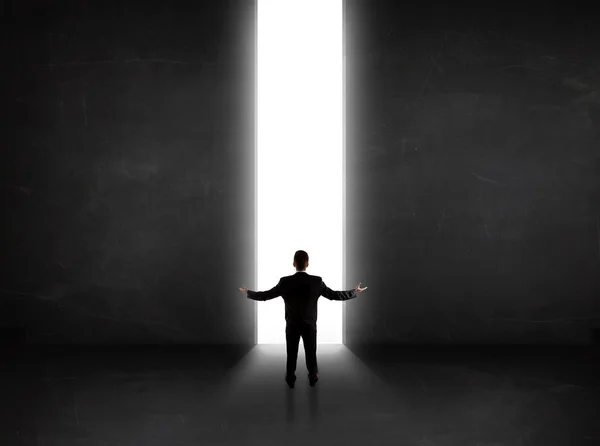 Persona de negocios mirando a la pared con apertura de túnel de luz — Foto de Stock