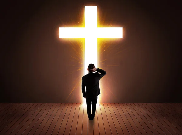 Man looking at bright cross sign — Stock Photo, Image