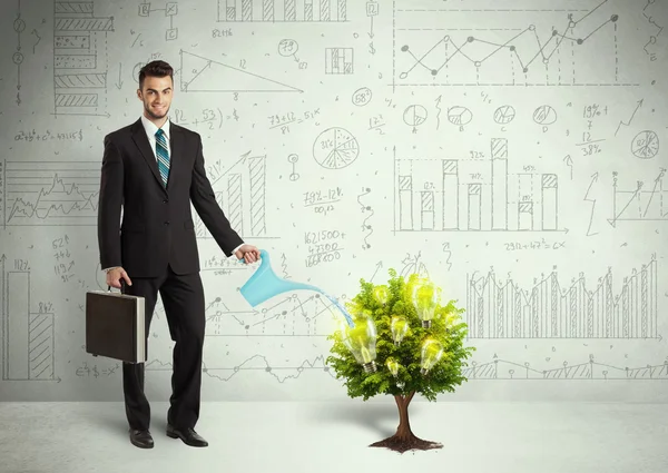 Business man pouring water on lightbulb growing tree — Stock Photo, Image