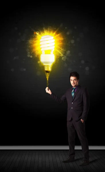 Empresário com uma lâmpada eco-friendly — Fotografia de Stock