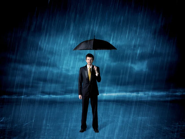 Geschäftsmann steht mit Regenschirm im Regen — Stockfoto