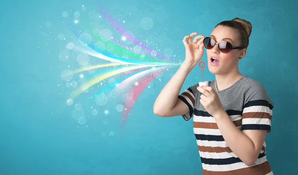Beautiful girl blowing abstract colorful bubbles and lines — Stock Photo, Image